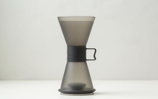 An Aeropress coffee maker, disassembled, showing its plunger and chamber.